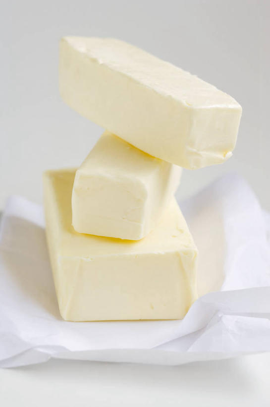 无人,竖图,俯视,室内,特写,白天,白色背景,餐桌,桌子,三块,一堆,切开,阴影,堆叠,堆积,反射,影子,黄油,黄色,切,摄影,影棚,餐台,堆,乳制品,白脱油,剖面,切面,乳脂,彩图,高角度拍摄,影棚拍摄,拍摄