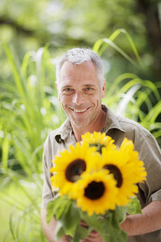 西方人,一个人,站,笑,微笑,露齿笑,竖图,室外,白天,正面,爱情,幸福,草地,草坪,太阳,植物,向日葵,欧洲,欧洲人,仅一个男性,仅一个人,仅一个中年男性,许多,握,阴影,服装,朦胧,模糊,盛开,光线,影子,拿,花蕾,拿着,注视,休闲装,草,花,花瓣,花朵,鲜花,树,树木,衣服,黄色,绿色,阳光,自然,花苞,花蕊,观察,看,站着,休闲,休闲服,握着,服饰,生长,成长,观看,察看,关注,光辉,沉默,忠诚,勇敢,投缘,爱慕,高傲,朝阳花,葵花,望日莲,向阳花,转日莲,男人,男性,中年男性,白种人,站立,半身,彩图