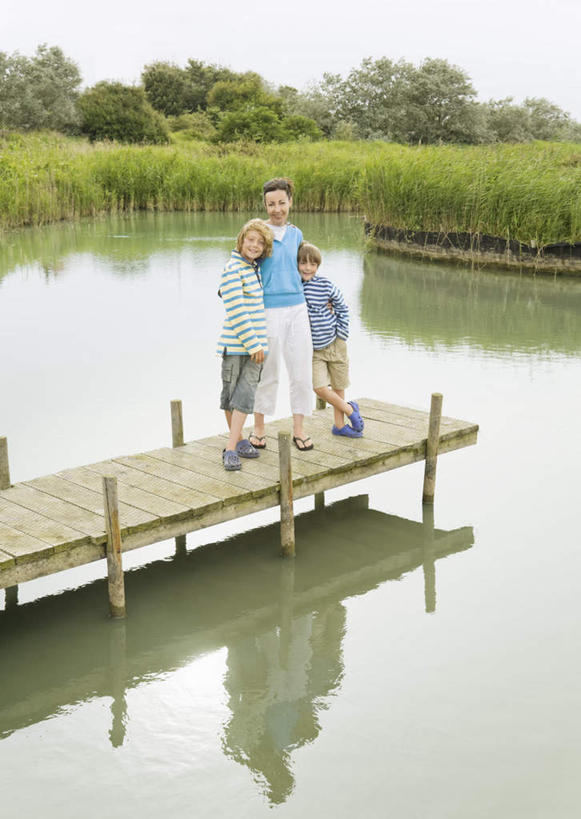 西方人,儿童,中年人,三个人,家庭,母亲,儿子,站,抱,竖图,室外,白天,正面,纯洁,草地,草坪,河流,水,植物,欧洲,欧洲人,服装,木板,河水,水流,桥,木桥,注视,休闲装,栈桥,草,树,树木,小孩,拍照,衣服,蓝色,绿色,倒影,天空,自然,天,观察,看,靠,靠着,站着,休闲,温暖,温馨,母子,一家人,休闲服,可爱,母爱,童年,童趣,摄影,服饰,生长,成长,抱着,观看,人行桥,木板桥,和睦,察看,倒映,搂着,关注,童真,烂漫,无邪,反照,天真,男孩,女人,女性,中年女性,白种人,孩子,搂,搂抱,站立,彩图,全身,照相,融洽,男生