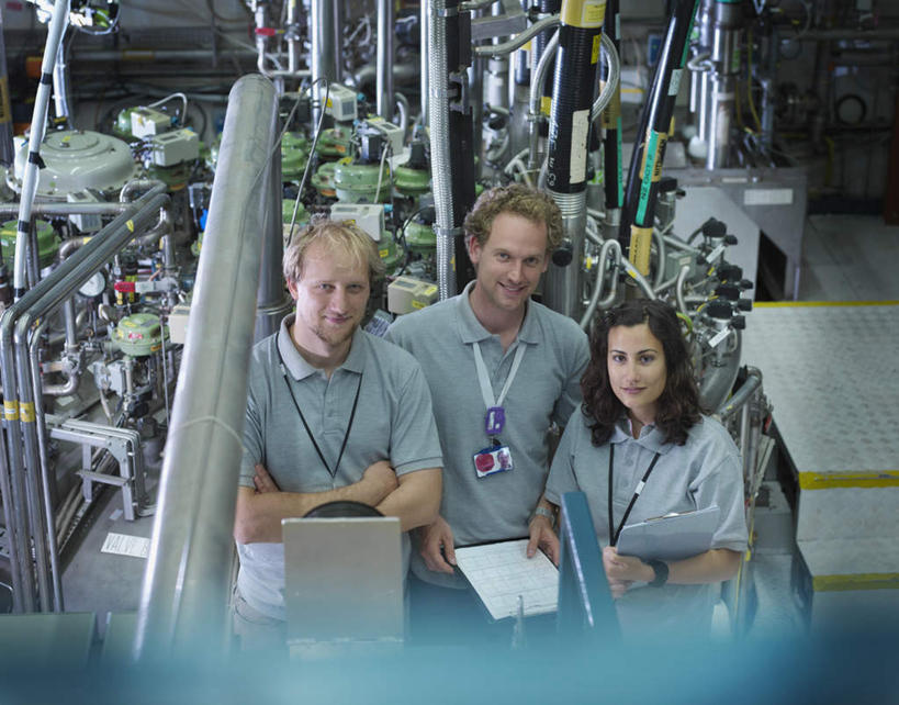 西方人,三个人,同事,科学家,栏杆,站,笑,微笑,露齿笑,横图,俯视,室内,白天,工作服,制服,成功,合作,团队,集体,信心,机器,摆设,金属制品,欧洲,欧洲人,一排,握,阴影,朦胧,模糊,整齐,电力,反射,金属,电线,管子,线,影子,围栏,电能,拿,线路,拿着,设备,标识,吊牌,管道,队伍,护栏,相视,排列,灰色,胸牌,站着,面对面,机械,发电厂,发电站,握着,对视,电,电源,电源线,核电站,核能,徽章,领导,互视,科研人员,成就,队列,相对,研究者,身份,记录板,能量,装备,合伙,领袖,记事板,胸章,胸卡,科学研究者,相看,编号牌,雕刻牌,工号牌,胸号牌,胸徽,员工牌,工作制服,设置,核电厂,男人,男性,年轻男性,年轻女性,女人,女性,白种人,科学工作者,站立,半身,彩图,高角度拍摄,工作套服