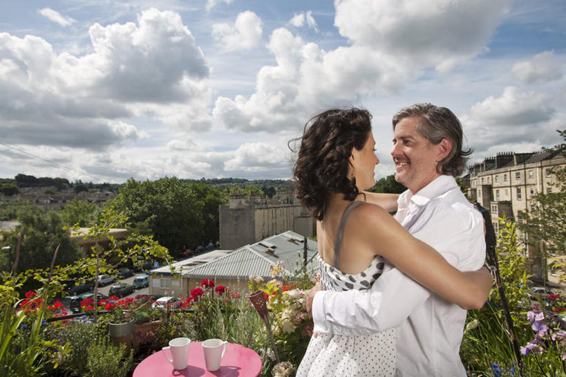 西方人,中年人,两个人,家庭,夫妻,家,站,抱,笑,微笑,露齿笑,横图,室外,白天,侧面,爱情,草地,草坪,山,山脉,植物,桌面,桌子,杯子,椅子,吊带,欧洲,欧洲人,阴影,服装,盛开,光线,木制,影子,陶瓷,房屋,墙,屋子,山峰,云,云朵,陶瓷制品,山峦,浪漫,花蕾,云彩,注视,吊带衫,楼房,相视,墙壁,墙面,住宅,草,花,花瓣,花朵,鲜花,树,树木,两个,衣服,蓝色,绿色,白色,白云,蓝天,天空,阳光,自然,马克杯,木制品,水杯,群山,天,花苞,花蕊,观察,看,站着,温暖,温馨,一家人,面对面,恩爱,恋人,服饰,生长,晴朗,成长,抱着,观看,对视,和睦,察看,互视,搂着,衣着,穿着,关注,相对,相看,衣饰,男人,男性,女人,女性,中年男性,中年女性,白种人,夫妇,情侣,晴空,怀抱,搂,搂抱,相抱,拥抱,站立,半身,彩图,房子,伴侣,融洽