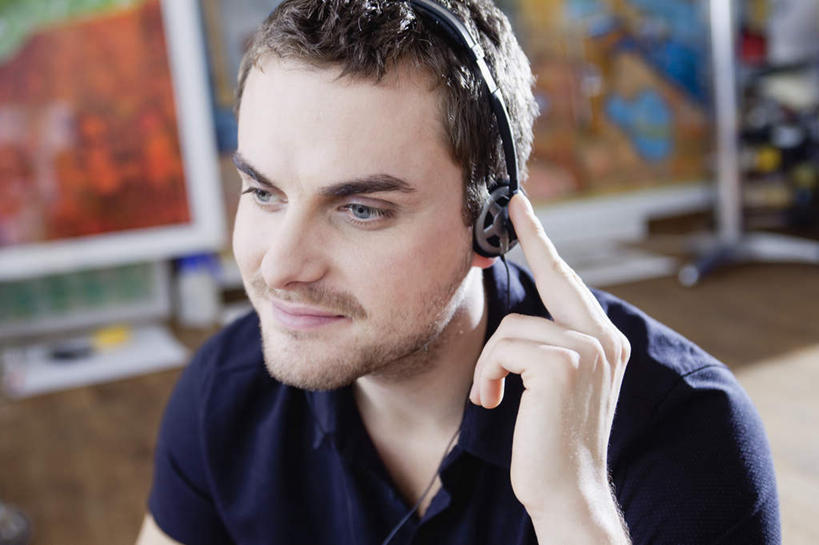 西方人,一个人,笑,微笑,横图,俯视,室内,白天,绘画,欧洲,欧洲人,仅一个男性,仅一个人,握,服装,朦胧,模糊,艺术,装饰,墙,拿,拿着,注视,休闲装,文化,壁画,墙壁,墙面,仅一个年轻男性,衣服,耳机,耳麦,观察,看,休闲,休闲服,握着,服饰,观看,华丽,修饰,点缀,察看,麦克风,关注,衬托,美观,雅致,雅观,男人,男性,年轻男性,白种人,画画,半身,彩图,高角度拍摄,头戴式耳机