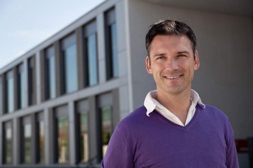 西方人,一个人,站,笑,微笑,露齿笑,横图,室外,白天,正面,窗户,欧洲,欧洲人,仅一个男性,仅一个人,仅一个中年男性,阴影,服装,光线,影子,墙,注视,休闲装,玻璃窗,墙壁,墙面,衣服,紫色,阳光,观察,看,站着,休闲,休闲服,服饰,观看,察看,关注,男人,男性,中年男性,白种人,站立,半身,彩图