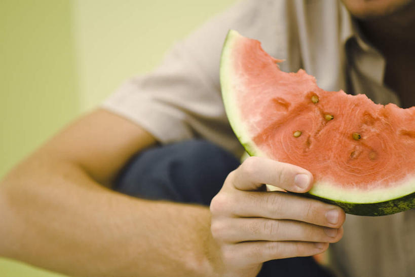 西方人,一个人,坐,吃,横图,室内,白天,正面,西瓜,欧洲,欧洲人,仅一个男性,仅一个人,一片,握,咬,服装,墙,拿,拿着,休闲装,墙壁,墙面,仅一个年轻男性,衣服,休闲,休闲服,握着,服饰,咬着,男人,男性,年轻男性,白种人,寒瓜,嚼,食,坐着,半身,彩图