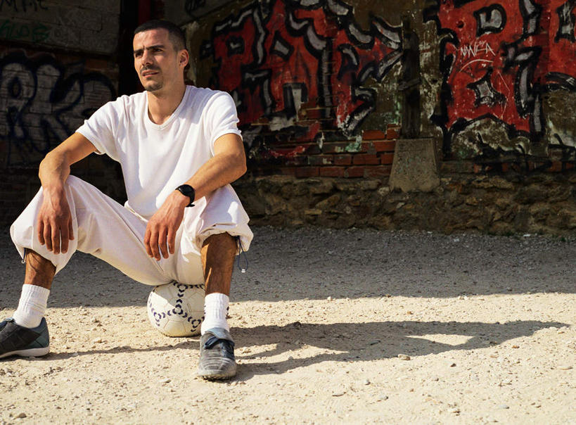 西方人,一个人,坐,横图,室外,白天,正面,锻炼,运动,足球,欧洲,非洲,黑人,欧洲人,仅一个男性,仅一个人,阴影,光线,影子,墙,足球装备,地面,注视,运动器械,墙壁,墙面,仅一个年轻男性,阳光,看,健身器械,观看,关注,室外运动,健身器材,户外运动,蹴鞠,足球运动,男人,男性,年轻男性,非洲人,坐着,半身,彩图,健身,涂鸦,运动器材