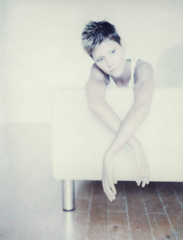 西方人,一个人,坐,双手交叉,竖图,室内,白天,正面,地板,沙发,欧洲,欧洲人,仅一个年轻女性,仅一个女性,仅一个人,背心,地面,木地板,趴着,布艺沙发,年轻女性,女人,女性,白种人,趴,坐着,半身,彩图,短发