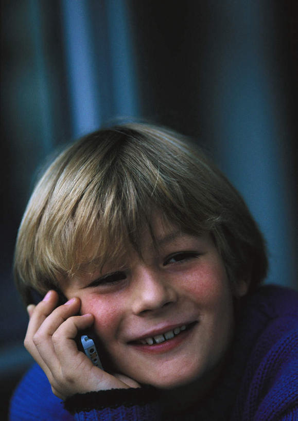 西方人,儿童,脸,头,脸颊,头发,一个人,坐,举,笑,打电话,微笑,露齿笑,竖图,室内,特写,白天,正面,毛衣,纯洁,电话,手机,欧洲,欧洲人,仅一个男性,仅一个人,握,朦胧,模糊,拿,听,拿着,注视,通讯设备,一个,小孩,黄色,蓝色,观察,看,托,仅一个小孩,可爱,童年,童趣,握着,单个,观看,察看,关注,童真,烂漫,无邪,交流,天真,男孩,男人,男性,白种人,孩子,头部,脸部,脸蛋,面部,沟通,举起,举手,举着,通话,向上举,向上伸,向上托,坐着,半身,彩图,绒衣,套衫,套头毛衣,线衣,男生