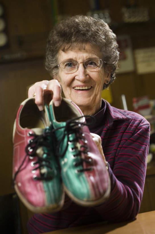 西方人,一个人,站,笑,微笑,露齿笑,竖图,室内,白天,正面,运动鞋,桌面,桌子,鞋子,欧洲,欧洲人,仅一个女性,仅一个人,一双,握,阴影,服装,反射,木制,眼镜,影子,保龄球馆,拿,拿着,注视,休闲装,衣服,木制品,观察,看,站着,休闲,休闲服,握着,服饰,仅一个老年女性,观看,老花镜,察看,关注,球馆,远视眼镜,老年女性,女人,女性,白种人,站立,半身,彩图,保龄球鞋