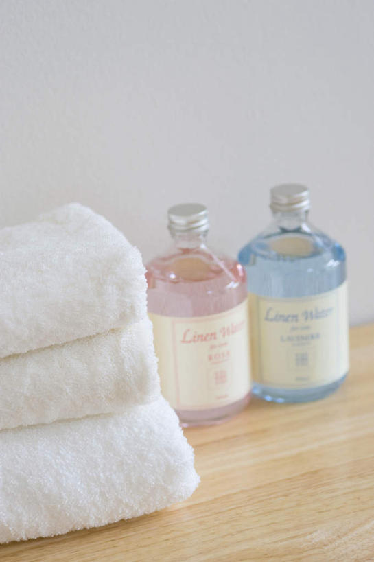 无人,竖图,室内,特写,白天,正面,桌面,桌子,静物,一排,整齐,纺织物,墙,粉红,墙壁,墙面,玻璃制品,排列,两个,粉色,蓝色,白色,玻璃瓶,瓶子,毛巾,清洁,三条,堆,保暖,队列,透气,防水,储水,耐磨,吸水,彩图