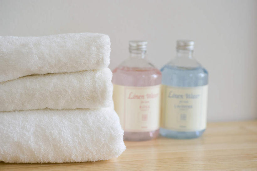 无人,横图,室内,特写,白天,正面,桌面,桌子,静物,一排,整齐,纺织物,墙,粉红,墙壁,墙面,玻璃制品,排列,两个,粉色,蓝色,白色,玻璃瓶,瓶子,毛巾,清洁,三条,堆,保暖,队列,透气,防水,储水,耐磨,吸水,彩图