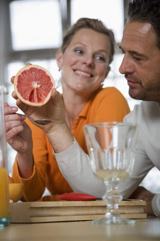 果汁,西方人,中年人,两个人,家庭,夫妻,站,笑,微笑,露齿笑,竖图,室内,白天,正面,爱情,厨房,窗户,落地窗,桌子,柑橘,杯子,水果,欧洲,欧洲人,握,服装,朦胧,模糊,新鲜,办公桌,生食,橙汁,食品,果实,饮品,浪漫,拿,拿着,注视,休闲装,葡萄柚,玻璃窗,玻璃制品,食物,饮料,衣服,水杯,西柚,观察,看,站着,休闲,温暖,温馨,一家人,休闲服,恩爱,握着,恋人,服饰,有机食品,绿色食品,观看,和睦,察看,关注,可口,朱栾,适口,男人,男性,女人,女性,中年男性,中年女性,白种人,夫妇,情侣,玻璃杯,橘子,桔子,橙子,橙,站立,半身,彩图,灶间,伴侣,融洽