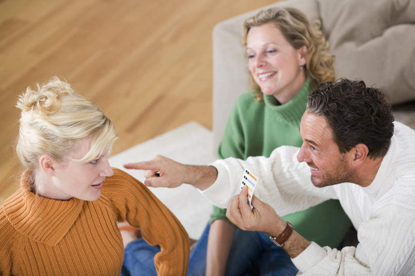 西方人,三个人,家庭,夫妻,母亲,父亲,女儿,笑,微笑,露齿笑,横图,俯视,室内,白天,爱情,游戏,赌博,贪欲,竞争,扑克牌,纸牌,玩具,扑克,欧洲,欧洲人,指,服装,朦胧,模糊,浪漫,玩,休闲装,方向,娱乐,刺激,衣服,手势,休闲,温暖,温馨,父女,母女,一家人,休闲服,恩爱,父爱,母爱,恋人,服饰,活动,和睦,指向,发泄,消遣,智力,赌具,投机,侥幸,欲望,宣泄,男人,男性,年轻女性,女人,女性,中年男性,中年女性,白种人,夫妇,情侣,玩耍,嬉戏,半身,彩图,高角度拍摄,伴侣,融洽,胜负,输赢