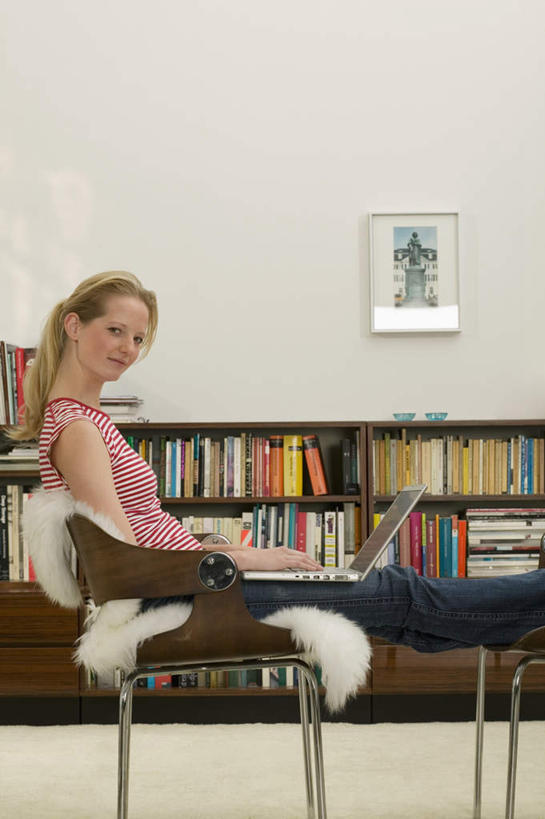 西方人,一个人,坐,笑,微笑,露齿笑,竖图,室内,白天,侧面,电脑,笔记本电脑,书架,书籍,欧洲,欧洲人,仅一个年轻女性,仅一个女性,仅一个人,服装,网络,墙,注视,休闲装,通讯设备,墙壁,墙面,衣服,白色,观察,看,休闲,休闲服,服饰,观看,察看,无线,关注,通信设备,无线网络,无线上网,便携式电脑,手提电脑,年轻女性,女人,女性,白种人,书,图书,坐着,半身,彩图