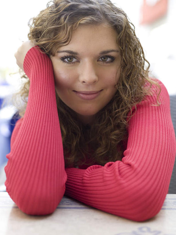 西方人,一个人,坐,笑,微笑,竖图,室内,白天,正面,桌面,桌子,欧洲,欧洲人,仅一个年轻女性,仅一个女性,仅一个人,撑,服装,木制,托腮,注视,休闲装,衣服,红色,木制品,观察,看,托,休闲,休闲服,服饰,观看,察看,关注,托下巴,年轻女性,女人,女性,白种人,坐着,半身,彩图