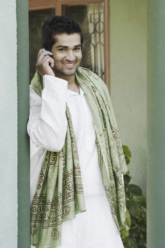 一个人,站,笑,打电话,微笑,露齿笑,竖图,室外,白天,正面,民族服装,门,电话,手机,亚洲,仅一个男性,仅一个人,握,服装,装饰,拿,拿着,注视,通讯设备,仅一个年轻男性,衣服,围巾,门框,观察,看,站着,温暖,握着,服饰,围脖,观看,保暖,华丽,点缀,察看,衣着,御寒,穿着,关注,衬托,美观,雅致,雅观,衣饰,交流,男人,男性,年轻男性,亚洲人,印度人,沟通,通话,站立,半身,彩图,传统服装,民俗服