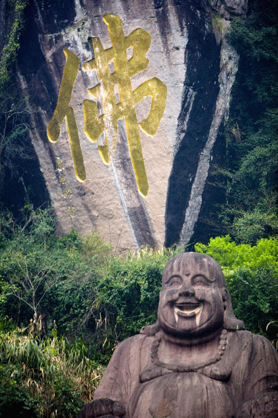 无人,坐,笑,微笑,竖图,室外,白天,正面,民族服装,旅游,度假,名胜古迹,树林,植物,标志建筑,地标,建筑,雕塑,武夷山,中国,亚洲,遗迹,艺术,装饰,雕刻,雕像,注视,古迹,文化,文物,娱乐,建设,古建筑,弥勒佛,石雕,石刻,树,树木,绿色,自然,石碑,工艺品,观察,看,祈祷,享受,休闲,健康,旅游胜地,放松,许愿,宗教,佛教,信仰,生长,成长,观看,纪念,祈求,美术,察看,关注,主题,陈列,福建,古文明,东亚,福建省,中华人民共和国,华东地区,功能,美学,闽,布袋和尚,布袋神,弥勒,弥勒菩萨,释教,平安,坐着,彩图,传统服装,民俗服,武夷山市