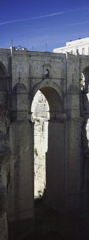 无人,竖图,室外,白天,正面,旅游,度假,石头,植物,标志建筑,地标,建筑,西班牙,欧洲,阴影,光线,石子,影子,悬崖,桥,娱乐,建设,石桥,安达卢西亚,拱桥,栈桥,树,树木,蓝色,绿色,蓝天,天空,阳光,自然,天,享受,休闲,旅游胜地,放松,拱形,生长,晴朗,成长,人行桥,石拱桥,南欧,安达鲁西亚,隆达,万里无云,西班牙王国,绝壁,安达卢西亚自治区,石块,晴空,晴空万里,彩图