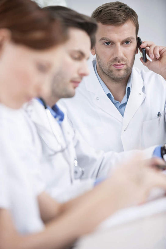 西方人,三个人,伙伴,朋友,医生,医院,坐,笑,打电话,微笑,露齿笑,竖图,室内,白天,侧面,工作服,制服,友谊,合作,团队,桌面,桌子,电话,手机,欧洲,欧洲人,握,朦胧,模糊,木制,笔,办公用品,拿,拿着,注视,通讯设备,水笔,文具,木制品,听诊器,学习用品,观察,看,医护人员,医疗人员,战略,握着,观看,文具用品,察看,医疗设备,书写,白大褂,关注,医疗器械,医疗工具,医疗机构,联合,合谋,工作制服,检测工具,交流,配合,协作,男人,男性,年轻男性,年轻女性,女人,女性,白种人,大夫,沟通,通话,坐着,半身,彩图,工作套服,病院,诊所