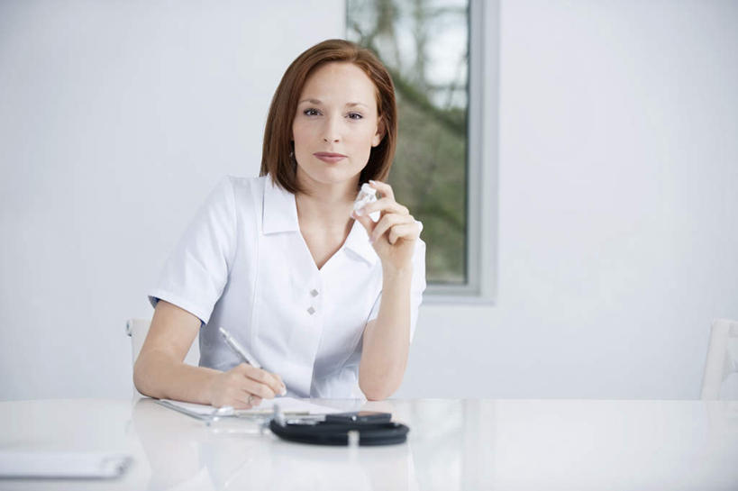 西方人,一个人,医生,办公室,医院,坐,笑,微笑,横图,室内,白天,正面,工作服,制服,窗户,家具,桌子,欧洲,欧洲人,仅一个年轻女性,仅一个女性,仅一个人,握,服装,笔,材料,档案,文件,纸,办公桌,墙,办公用品,拿,拿着,注视,水笔,玻璃窗,墙壁,墙面,文具,衣服,手稿,学习用品,资料,观察,看,医护人员,医疗人员,握着,服饰,观看,文具用品,证明,察看,衣着,穿着,关注,文档,医疗机构,办公家具,工作制服,衣饰,年轻女性,女人,女性,白种人,大夫,坐着,半身,彩图,工作套服,病院,诊所