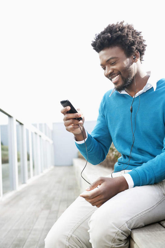 西方人,一个人,栏杆,坐,笑,微笑,露齿笑,竖图,室外,白天,正面,陶醉,快乐,满意,幸福,椅子,欧洲,非洲,黑人,欧洲人,仅一个男性,仅一个人,握,服装,朦胧,模糊,围栏,音响,音乐,音乐播放器,注视,休闲装,娱乐,护栏,仅一个年轻男性,衣服,耳机,观察,看,享受,休闲,休闲服,放松,握着,服饰,观看,察看,舒适,享乐,关注,MP3播放器,男人,男性,年轻男性,非洲人,坐着,半身,彩图,播放器,沉醉