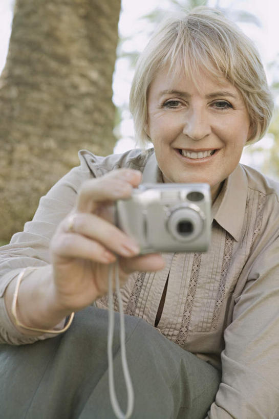 西方人,一个人,坐,笑,微笑,露齿笑,竖图,室外,白天,正面,植物,棕榈树,相机,叶子,欧洲,欧洲人,仅一个女性,仅一个人,握,服装,绿叶,拿,拿着,注视,休闲装,树,树木,拍照,衣服,绿色,自然,数码相机,观察,看,仅一个中年女性,休闲,休闲服,嫩叶,握着,摄影,服饰,生长,成长,观看,察看,关注,棕榈叶,女人,女性,中年女性,白种人,叶,叶片,照相机,坐着,半身,彩图,照相