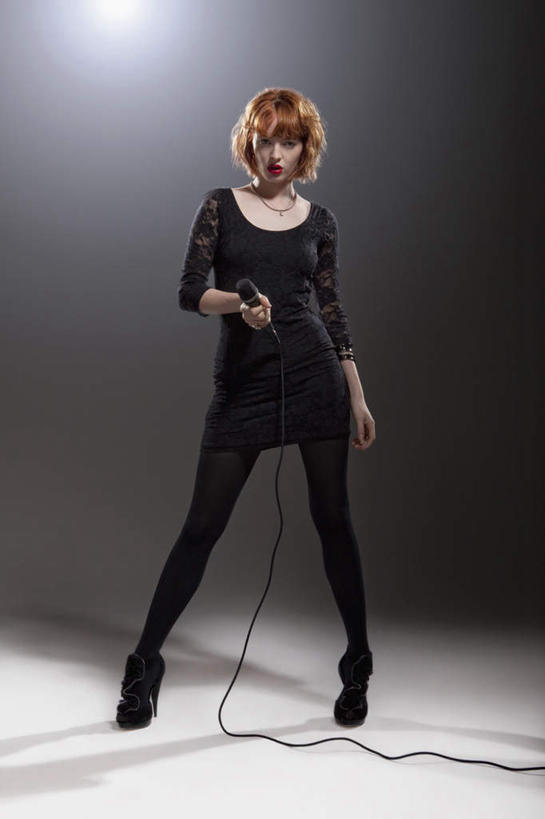 西方人,一个人,站,竖图,室内,白天,正面,欧洲,欧洲人,仅一个年轻女性,仅一个女性,仅一个人,握,阴影,黑色背景,服装,光线,影子,灯光,拿,拿着,注视,休闲装,衣服,话筒,观察,看,站着,休闲,休闲服,握着,摄影,服饰,影棚,观看,张开双腿,察看,麦克风,关注,扩音器,传声器,微音器,展开双腿,年轻女性,女人,女性,白种人,站立,彩图,全身,影棚拍摄,拍摄,伸展双腿