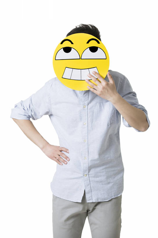 年轻男子戴着一张卡通笑脸